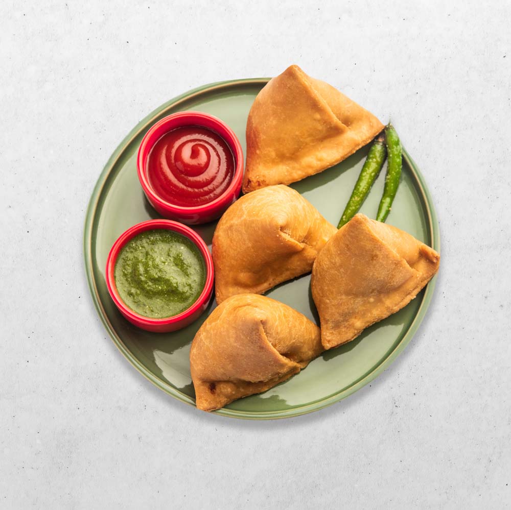 Vegetarian Aloo samosa or samosas. Indian special traditional street food.  Famous Indian Punjabi samosa filled with spicy boiled potato mixture.  served with green and red chutneys. Copy space. Photos